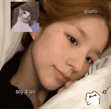 a woman laying on a bed with a picture of a cat and the words soy d lan below her
