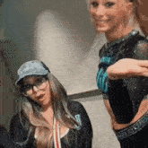 two cheerleaders are standing next to each other and smiling .