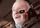 a man with a beard is wearing headphones and a microphone on his head .