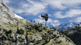 a helicopter is flying over a mountain range with trees on the side