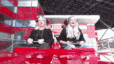 two women are riding a roller coaster and one is wearing glasses