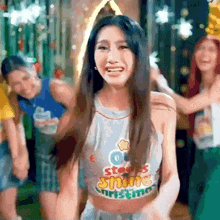 a woman wearing a crop top with the word shine on it is dancing .