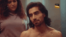 a man without a shirt is standing next to a woman and a sony logo