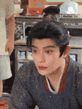 a man with a bun on his head is looking at something