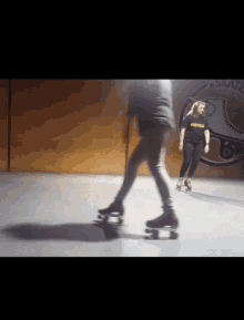 two people rollerblading in front of a wall that says a-state