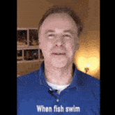 a man in a blue shirt says " when fish swim " in white letters