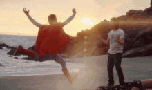 a man in a superman costume jumps in the air