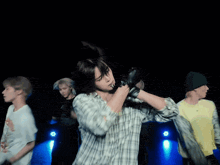 a man in a plaid shirt is dancing with a group of people