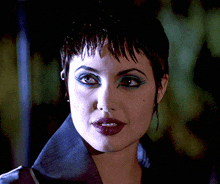 a close up of a woman 's face with purple lipstick and blue eyeshadow