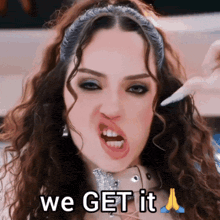 a woman with curly hair is making a funny face with the words we get it above her