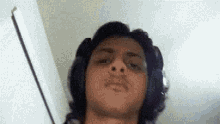 a man wearing headphones is taking a selfie with his face visible .