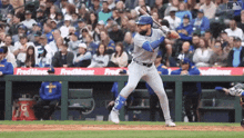 a baseball player is swinging at a pitch in front of a crowd sponsored by fred meyer ..