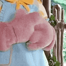 a close up of a person holding a pink stuffed animal .