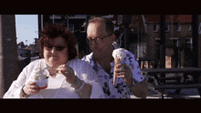 a man and a woman are eating ice cream in front of a sign that says " ribs "