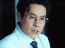 a close up of a man wearing glasses and a white shirt and tie