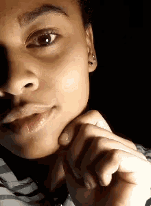 a close up of a person 's face with a hand on their chin