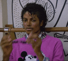 a man wearing a pink shirt with a mickey mouse on the front