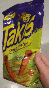 a person holds a bag of takis chile limon