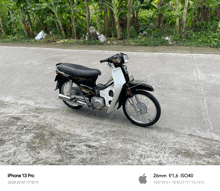 a black and white motorcycle is parked on a sidewalk
