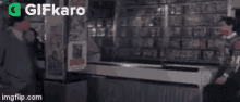 two men are talking to each other in a store .