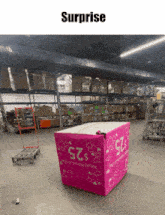 a pink box in a warehouse that says surprise on it
