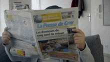 a person is reading a newspaper with the title la presse de gray