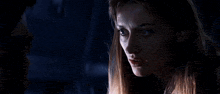 a man and a woman are looking at each other in the dark .