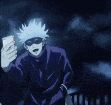 a man in a purple suit is taking a selfie with his phone .