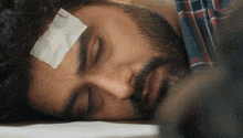 a man with a bandage on his forehead is laying on the ground