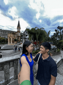 a man and woman are standing in front of a church