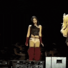 two women are dancing on a stage in front of a green laser beam .