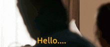 a blurred image of a person saying hello in yellow letters