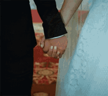 a bride and groom are holding hands with their wedding rings on