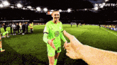 a soccer player wearing a green jersey with a vw logo