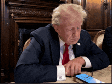 a man in a suit and tie is looking at a phone