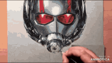 a person is drawing an ant man helmet with a brush