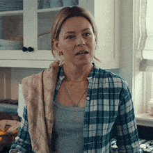 a woman in a plaid shirt has a towel around her shoulder