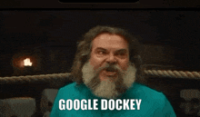 a man with a beard is standing in a boxing ring and says google docker