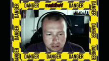 a man wearing headphones is surrounded by a yellow tape that says danger