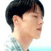 a close up of a man 's face with a plaid shirt on