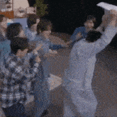 a group of people are standing around a man holding up a piece of paper