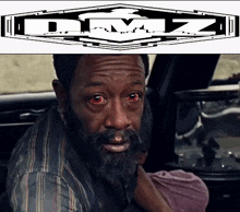 a man with a beard and red eyes is next to a logo for dmz
