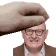a hand is holding a man 's head in a pixelated image .
