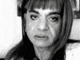 a black and white photo of a woman 's face with a serious expression