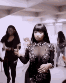 a woman in a black dress is dancing in a room with other people .
