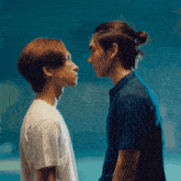 two men are looking at each other and one has a bun on his hair