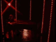 a man is sitting at a piano and singing into a microphone .