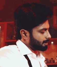 a man with a beard wearing a white shirt and black suspenders