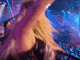 a blurry picture of a woman dancing in front of a crowd at a concert