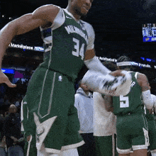 a basketball player in a green uniform with the number 34 on it